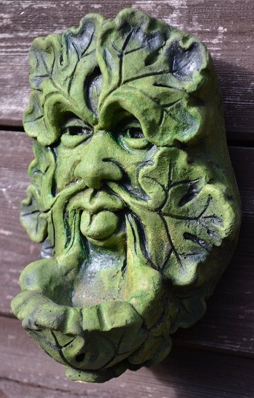 Green man wall plaque poking out his tongue 